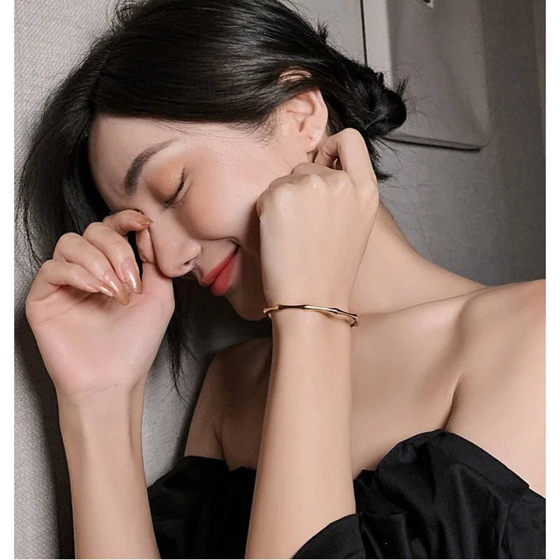 Woman wearing gold bamboo-style bangle close-up
