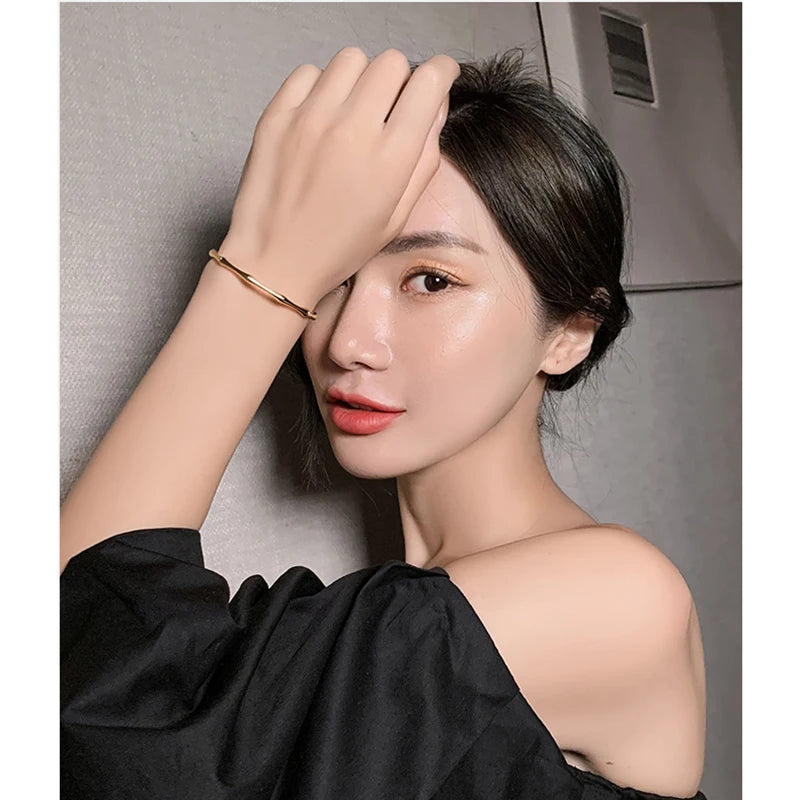 Stylish gold open bangle bracelet worn on wrist
