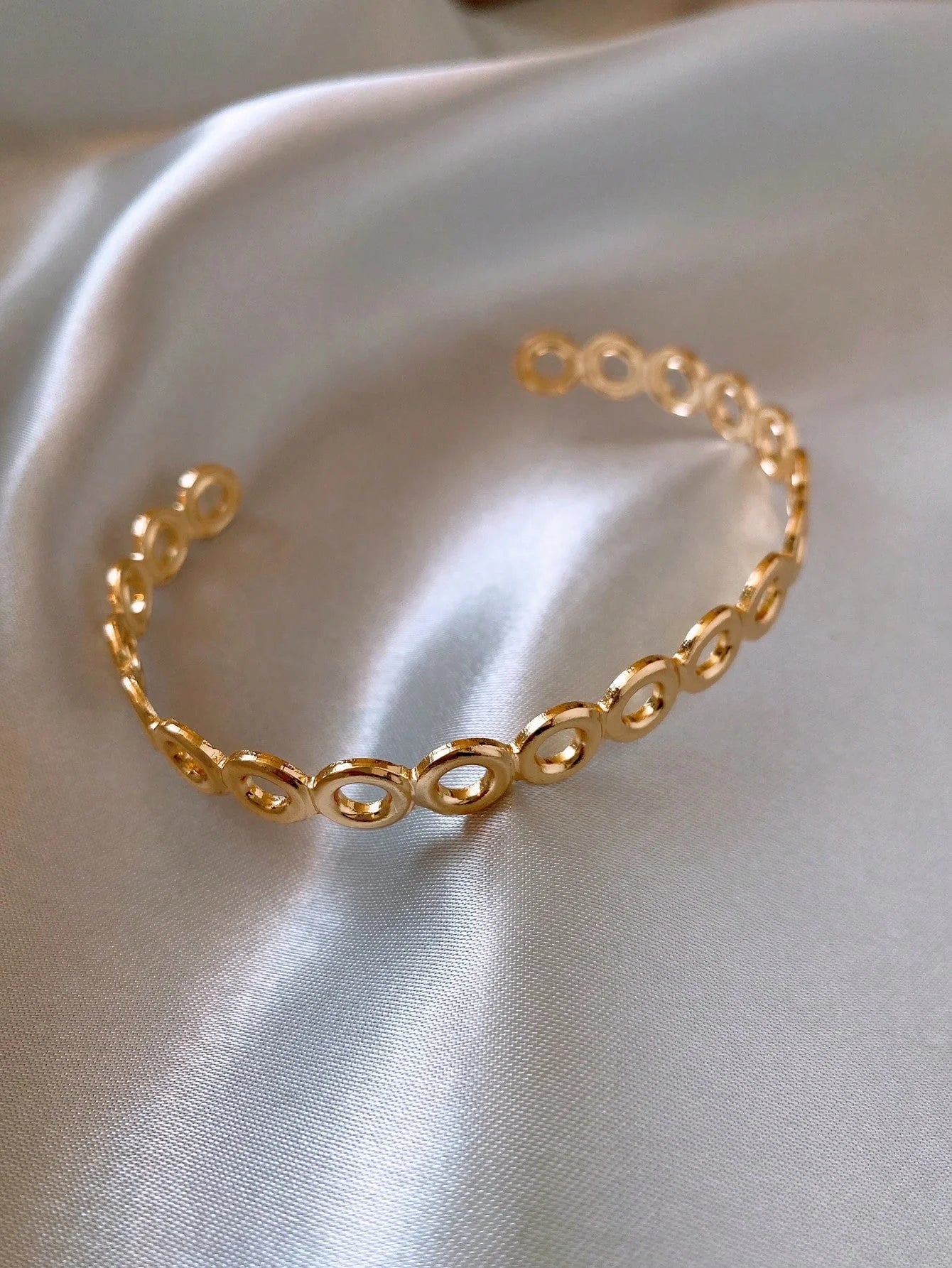 Trendy gold bracelet on silk fabric